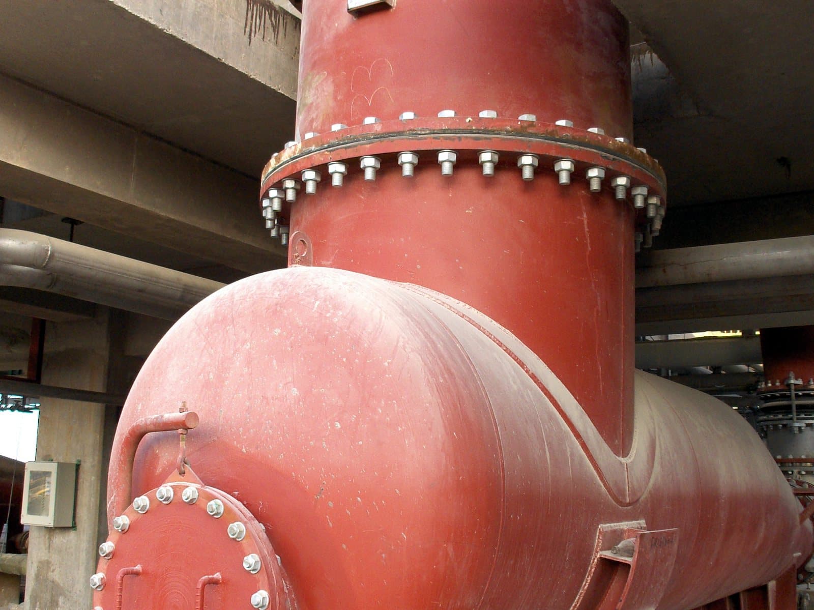 The steel header bolted in place beneath the structure of the process unit