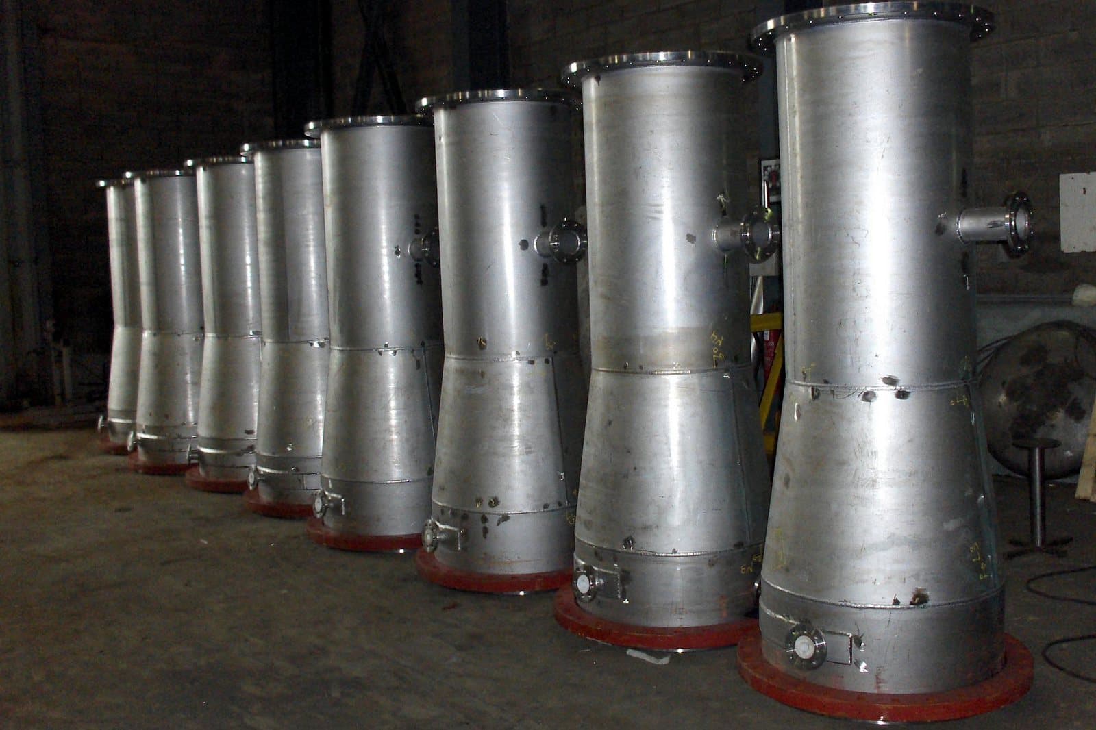 A row of stainless steel cone sections standing in the workshop
