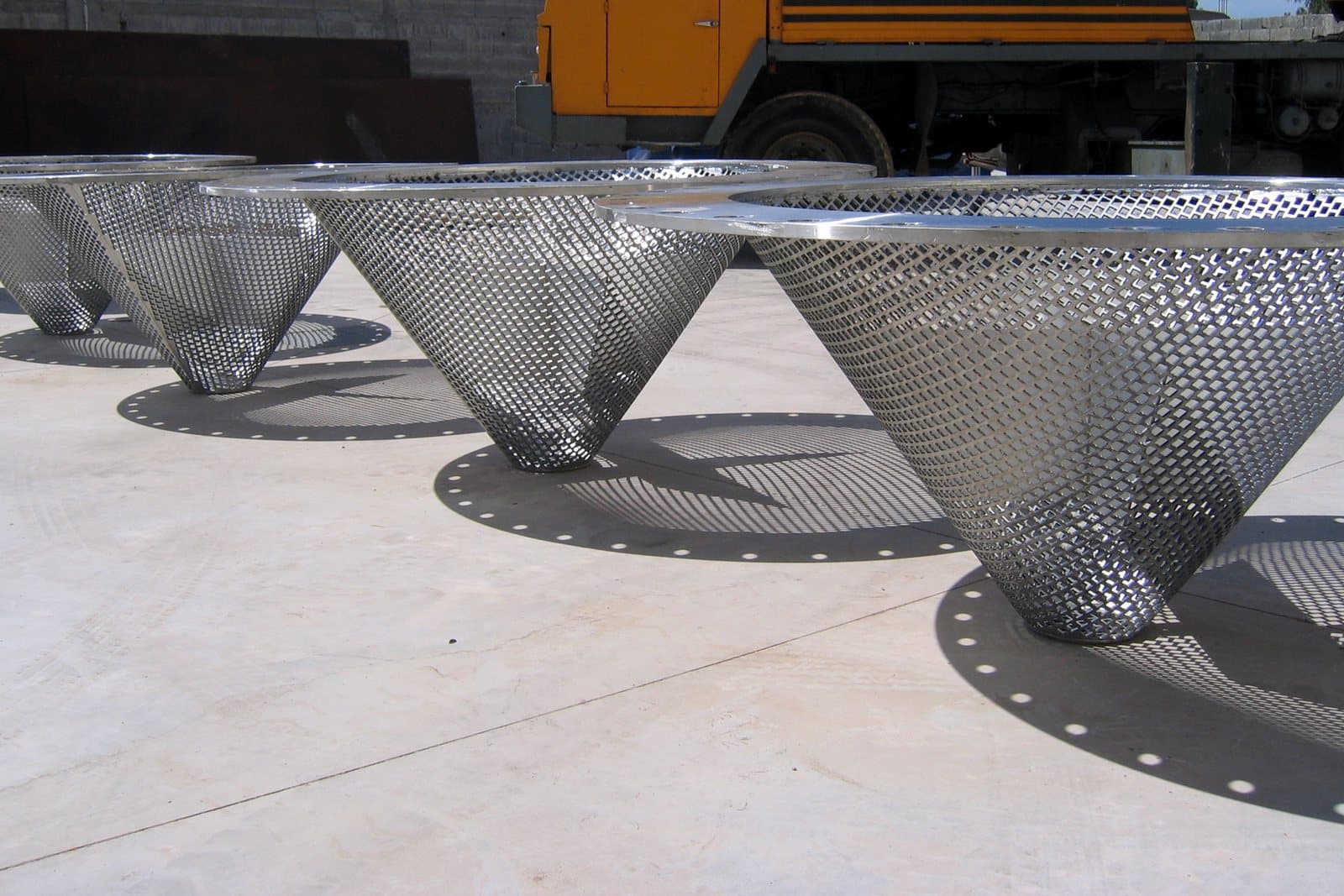 Conical perforated filters in UB6 stainless steel laid out on the yard