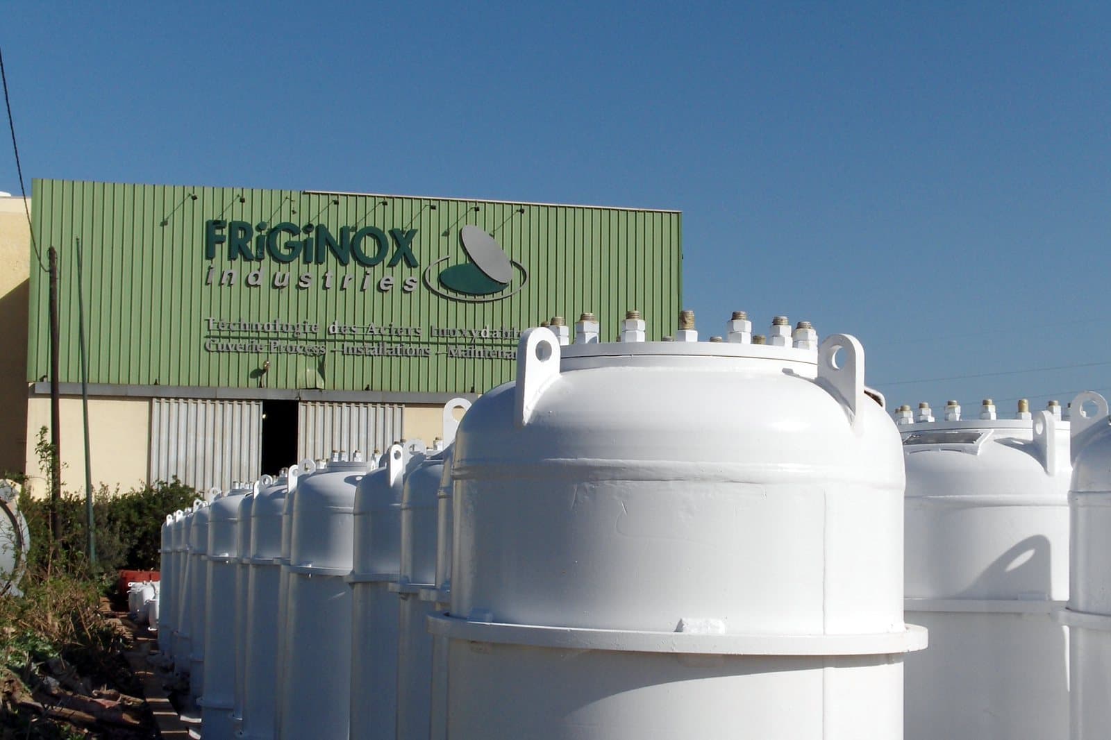 Rows of white chlorine pressure tanks lined up in front of the Friginox workshop